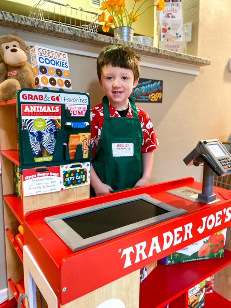 Kid playing with a Trader Joe's themed grocery play store